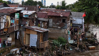Mensen doen hun activiteiten in een sloppenwijk aan de oevers van de Ciliwung-rivier in Manggarai, Jakarta, woensdag 15 april 2020.