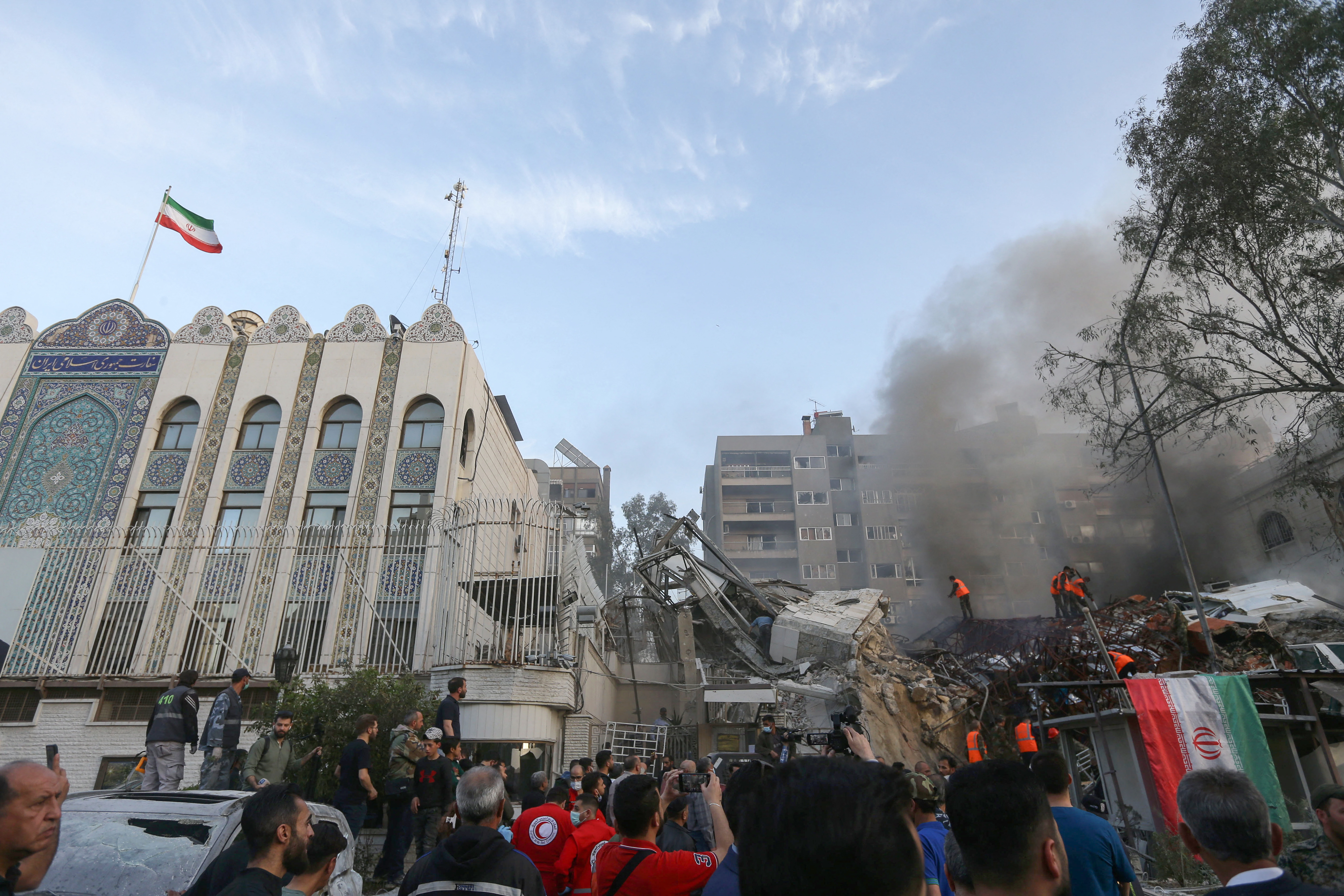 Personel darurat dan keamanan mencari puing-puing di lokasi serangan yang menghantam gedung yang merupakan bagian dari kedutaan Iran di ibu kota Suriah, Damaskus, Minggu (1/4/2024). (Foto: AFP/Louai Beshara)