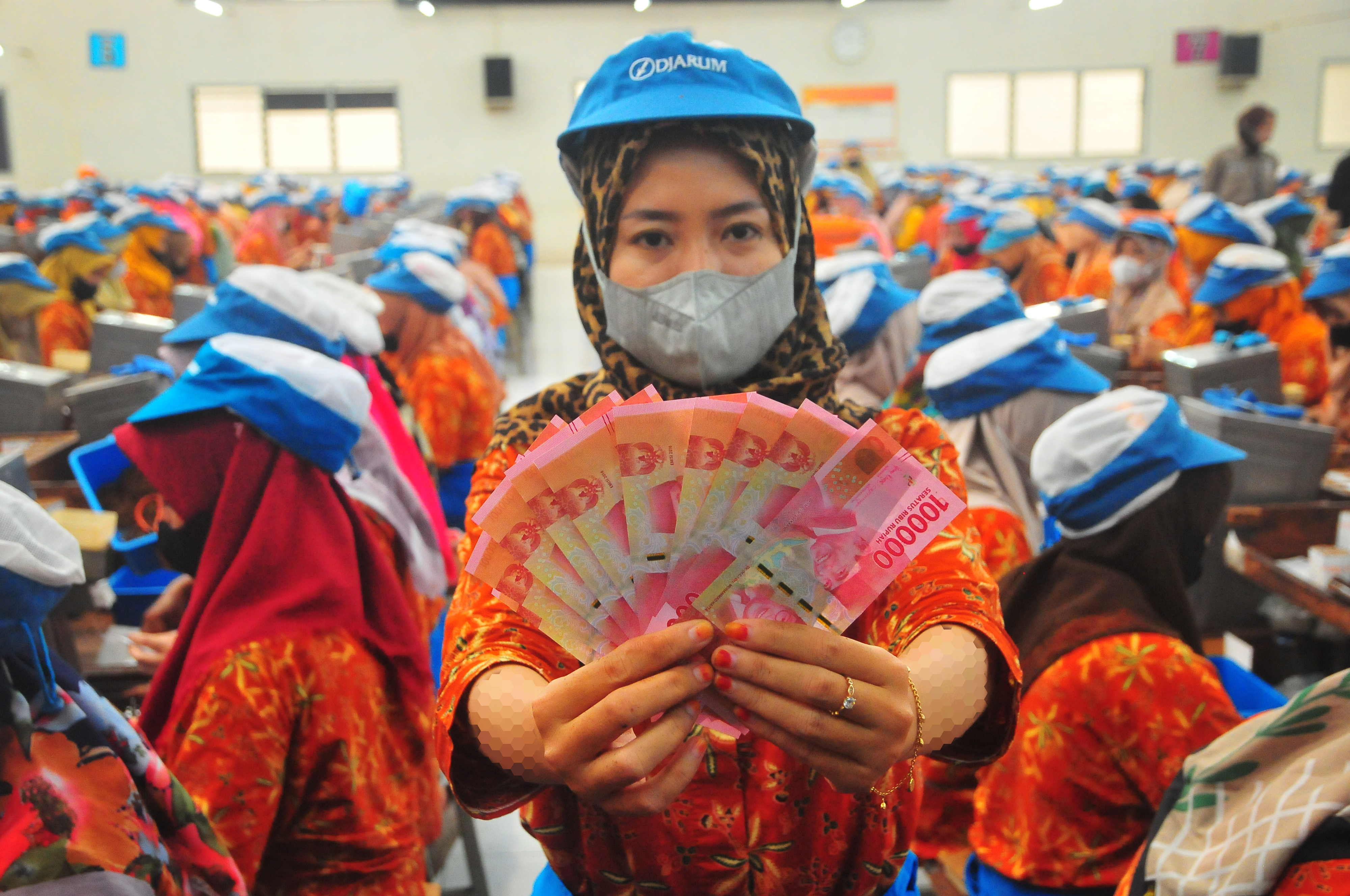 Pekerja menunjukkan uang tunjangan hari raya (THR) yang diterimanya saat pembagian di pabrik rokok Djarum, Kudus, Jawa Tengah, Selasa (2/4/2024). (Foto: ANTARA/Yusuf Nugroho)