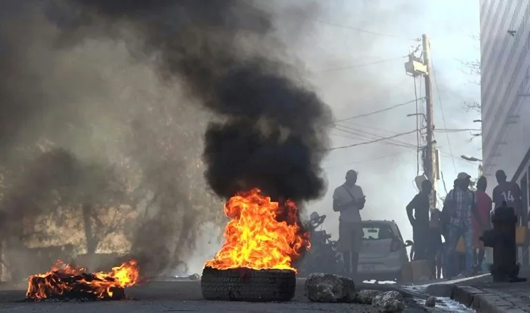 Sebuah ban dibakar di dekat penjara utama di Port-au-Prince, Haiti, Minggu (3/3/2024). Ibu kota Haiti itu kini dalam kekacauan usai serangan di penjara membebaskan banyak narapidana. (Foto: AFP/Luckenson Jean)