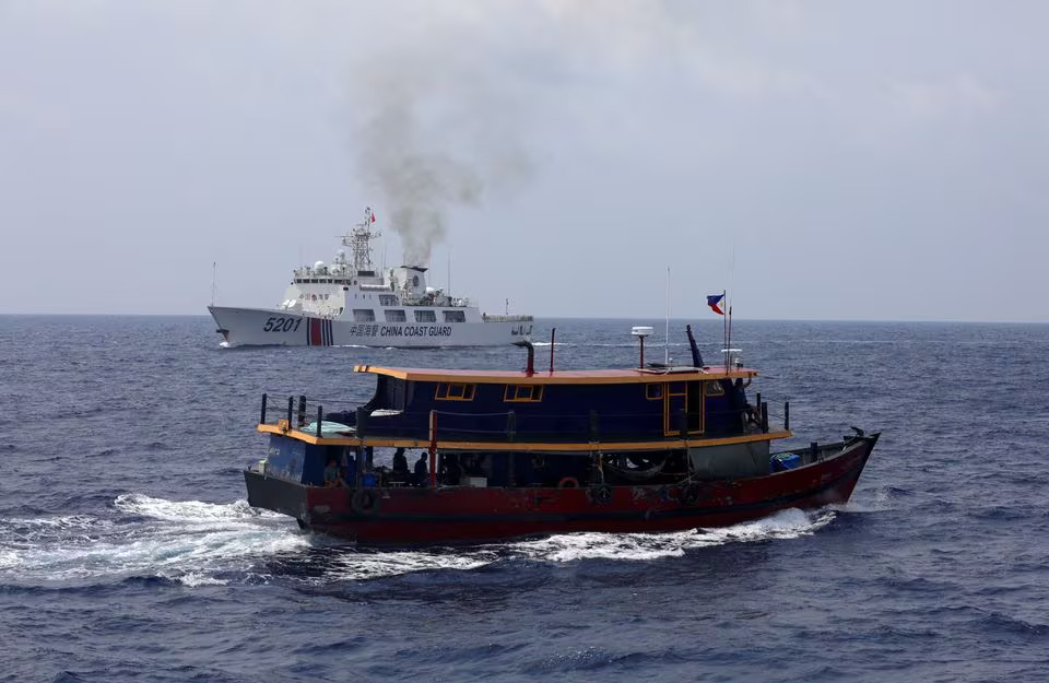 Kapal perbekalan Filipina berlayar di dekat kapal Penjaga Pantai Tiongkok di Laut Tiongkok Selatan, Rabu (10/4/2023). (Foto: Reuters/Adrian Portugal)