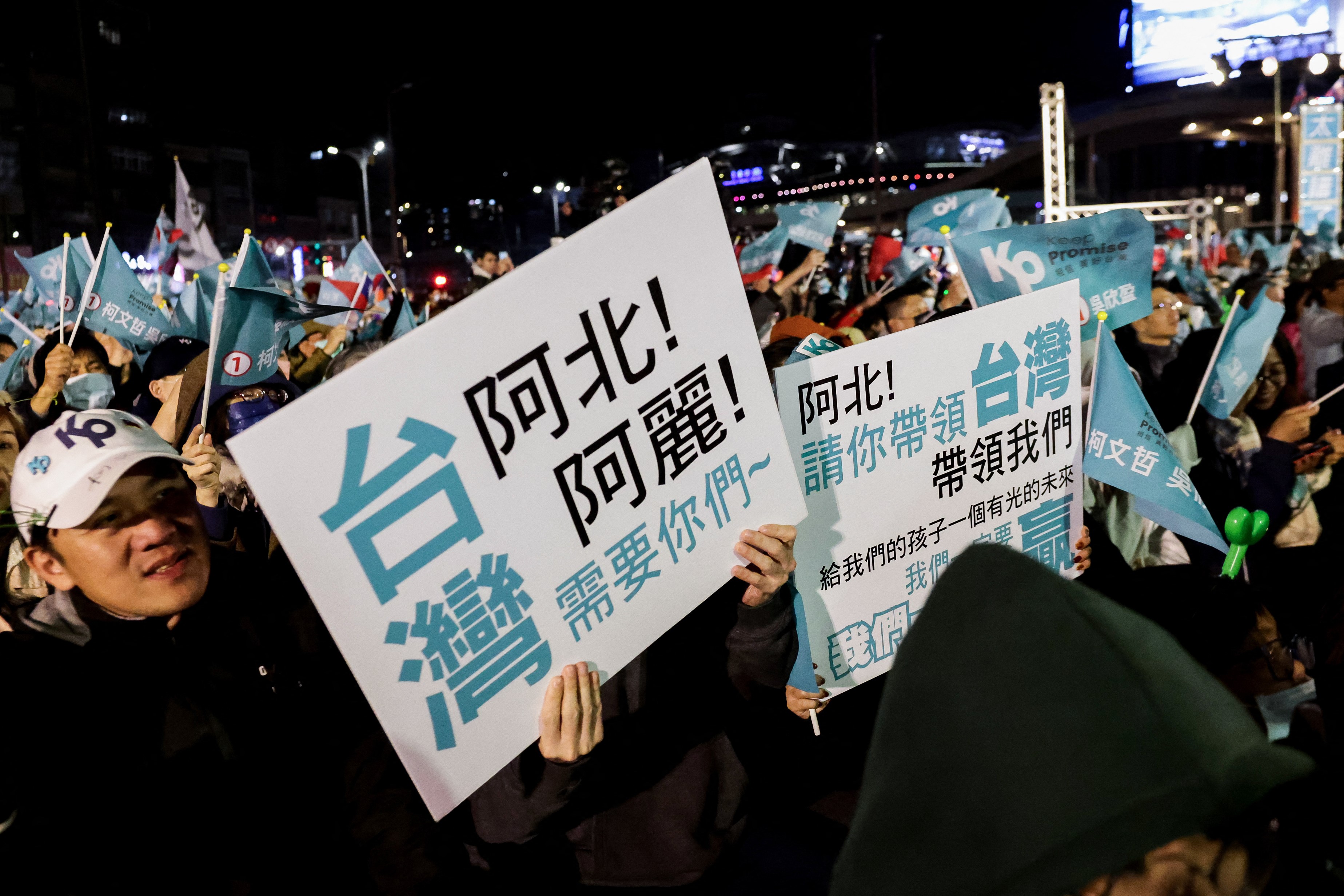 Para pendukung Partai Rakyat Taiwan (TPP) memegang papan bertuliskan 'Taiwan butuh Anda, berikan masa depan cerah bagi anak-anak kita' pada rapat umum kampanye partai tersebut di Keelung pada Rabu (10/01/2024). (Foto: AFP/I-Hwa Cheng)