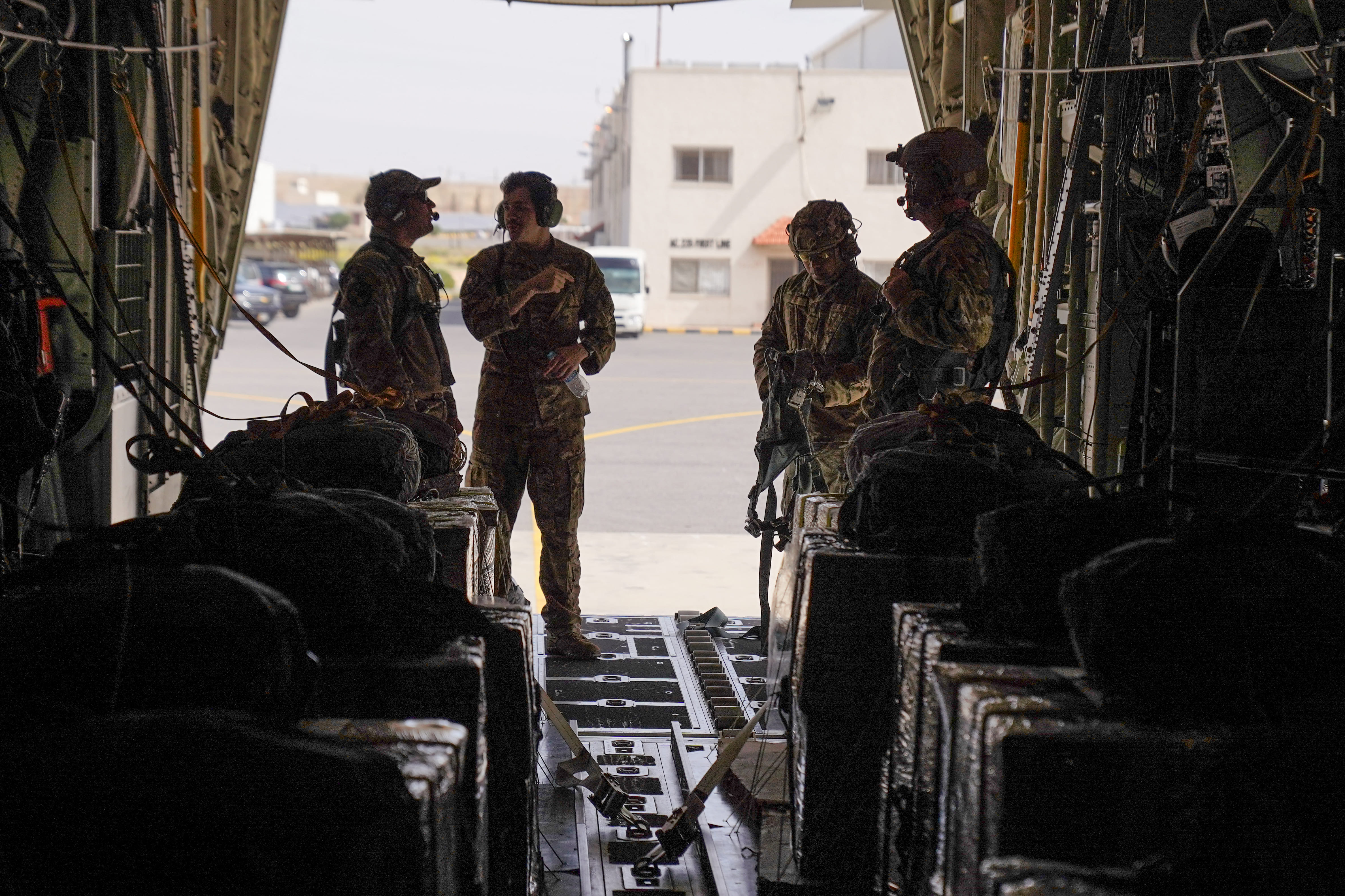 Anggota Angkatan Udara AS yang menaiki pesawat HC-130J bersiap-siap di pangkalan udara di Yordania, sebelum terbang menuju Jalur Gaza dalam misi menjatuhkan bantuan kemanusiaan yang dipasok Yordania pada Kamis (14/3/2024). (Foto: AFP/Dylan Collins)