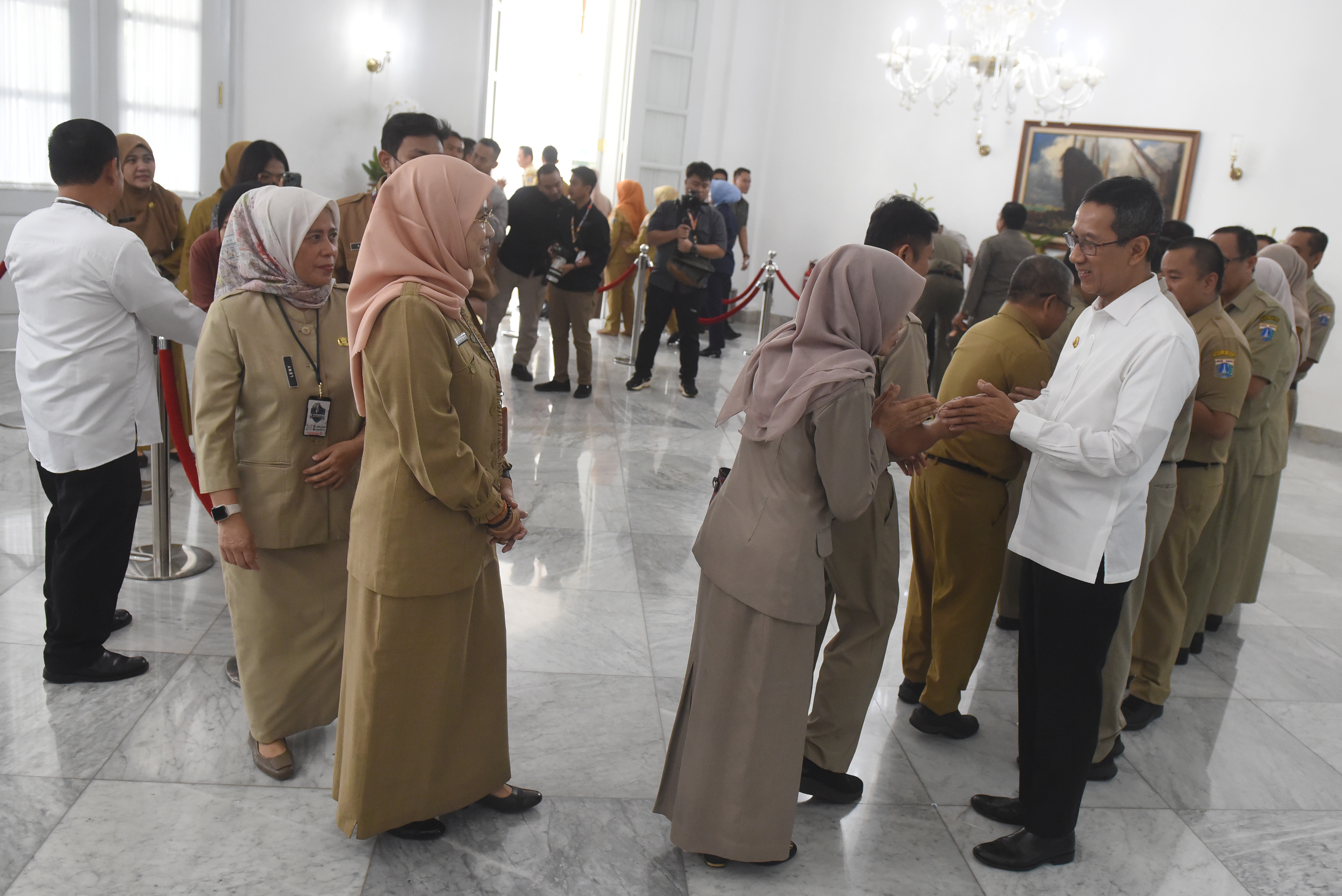 Penjabat Gubernur DKI Jakarta, Heru Budi Hartono (kanan) menyalami Aparatur Sipil Negara (ASN) di Balai Kota DKI Jakarta, Selasa (16/4/2024). (Foto: ANTARA/Indrianto Eko Suwarso)