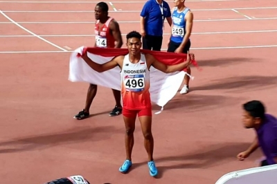 Sprinter Lalu Muhammad Zohri mengibarkan Bendera Merah Putih usai meraih medali perak Kejuaraan Atletik Asia 2019 di Doha, Qatar, Senin (22/4/2019). (Tim media PB PASI)
