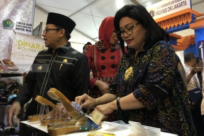 Deputi Bidang Produksi dan Pemasaran Kementerian Koperasi dan Usaha Kecil Menengah (UKM) Victoria Simanungkalit saat melihat salah satu produk yang dipamerkan dalam Malang City Expo 2019, di Kota Malang, Jawa Timur, Kamis (18/7/2019).