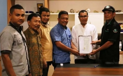 CSR &amp; Corcomm Senior Manager PT Mifa Bersaudara, Azizon Nurza disaksikan Kepala Dinas Energi dan Sumber Daya Mineral (ESDM) Aceh, Mahdinur (tengah) menyerahkan dokumen batu giok kepada Perkumpulan Pengusaha Pengrajin dan Penambang Batu Giok Aceh Indonesia (P3GAI) di Banda Aceh, Sabtu (14/9/2019).