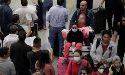 Wisatawan memakai masker pelindung di Bandara Internasional Galeao di RIo de Janeiro, Brazil, setelah laporan kasus virus corona baru, Jumat (6/3/2020). REUTERS/Ricardo Moraes/nz/cfo (REUTERS/RICARDO MORAES)