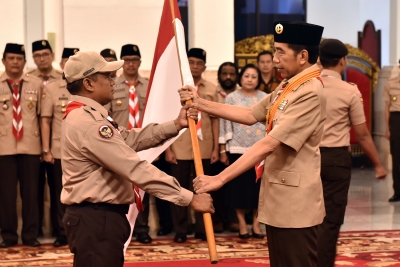 Presiden Jokowi menyerahkan bendera Merah Putih kepada ketua kontingan saat melepas delegasi Pramuka Indonesia pada Jambore Pramuka Dunia, di Istana Negara, Jakarta, Jumat (19/7) pagi.