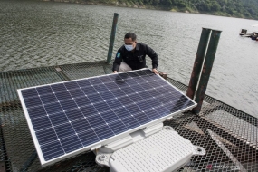 官员在西爪哇西万隆摄政区 Cipeundeuy 区 Cirata 水库地区的 Cirata 浮动太阳能发电厂的第一座建筑落成前检查浮动太阳能电池板