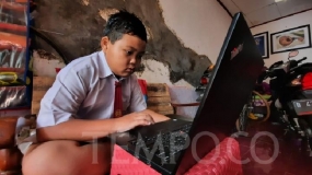 Een tweede klas van de basisschool legt zijn eindexamen 2019-2020 online af vanuit zijn huis in Kampung Baru 1 Halim Perdanakusuma, Oost-Jakarta, maandag 8 juni 2020. 