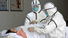 Medisch personeel van het Second People’s ziekenhuis ontfermt zich over een met corona geïnfecteerde patiënt.