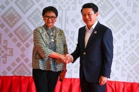 Indonesiens Außenministerin  Retno Marsudi schüttelt dem laotischen Premierminister Saleumxay Kommasith die Hand. (AFP)