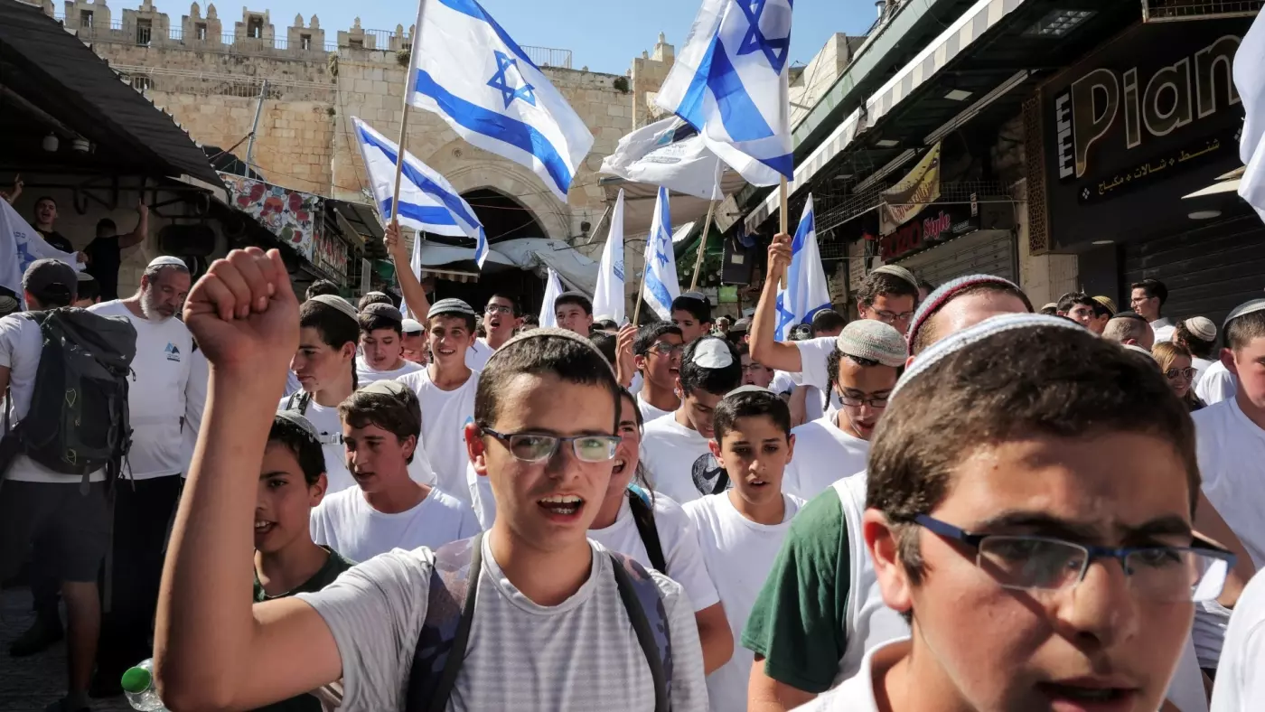 Warga Israel mengibarkan bendera Israel di Yerusalem saat mereka berpartisipasi dalam pawai tahunan 