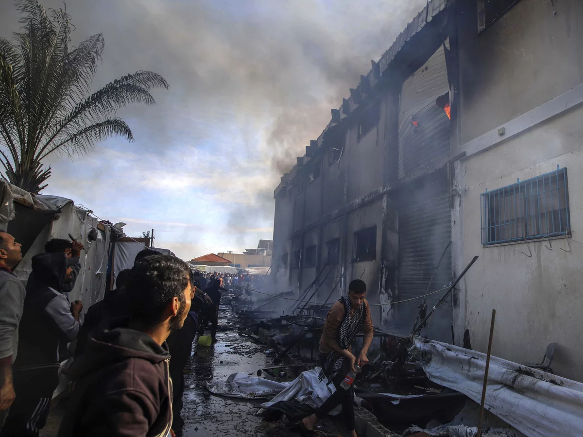 Warga Palestina mencoba memadamkan api di gedung pusat pelatihan vokasi UNRWA di Khan Younis, Jalur Gaza, Palestina pada Rabu (24/1/2024). (Foto: AP/Ramez Habboub)