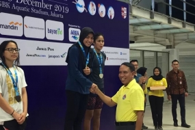 Menteri Pemuda dan Olahraga (Menpora) Zainudin Amali (kanan bawah) berjabat tangan dengan peraih medali emas nomor 400 m gaya bebas putri Adinda Larasati Dewi pada Indonesia Open Aquatic Championship (IOAC) 2019 di Stadion Akuatik Gelora Bung Karno Jakarta, Jumat (14/12/2019). (ANTARA/Shofi Ayudiana)