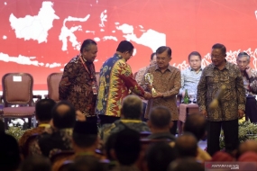 Wakil Presiden Jusuf Kalla (kedua kanan) didampingi Gubernur Bank Indonesia Perry Warjiyo (kiri) dan Menteri Perekonomian Darmin Nasution (kanan) memberikan penghargaan Tim Pengendalian Inflasi Daerah (TPID) 2018 Provinsi Terbaik 2018 kepada Gubernur DKI Jakarta Anies Baswedan (kedua kiri) saat Rapat Koordinasi Nasional Pengendalian Inflasi 2019 di Jakarta, Kamis (25/7/2019).