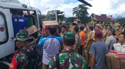 Masyarakat mengantre bantuan dari BNPB yang didatangkan melalui helikopter, Senin (10/6). 