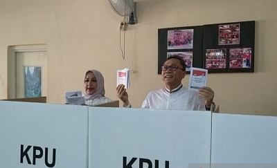 Ketua MPR RI Zulkifli Hasan (kanan) bersama istrinya, Soraya, menunjukkan kertas surat suara yang selesai dicoblos di TPS 167 Cipinang Muara, Jatinegara, Jakarta Timur, Rabu (17/4/2019).