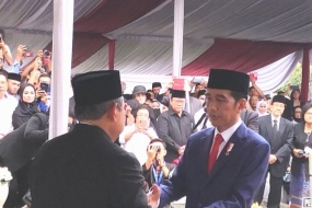 Presiden Jokowi menyerahkan bendera merah putih dan naskah Apel Persada kepada Susilo Bambang Yudhoyono usai pemakaman Ani Yudhoyono di TMP Kalibata Jakarta Minggu (2/6/2019)