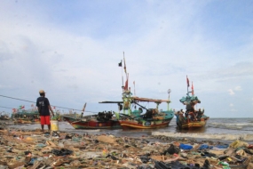 Nelayan menyandarkan perahunya di bibir pantai yang dipenuhi sampah plastik di Desa Dadap, Indramayu, Jawa Barat, Senin (26/11/2018). LSM World Wild Fund for Nature (WWF) Indonesia menilai masalah pencemaran sampah plastik di laut Indonesia sudah bisa disebut sebagai darurat sampah plastik karena perlu penanganan serius. (ANTARA FOTO/Dedhez Anggara/aww.)