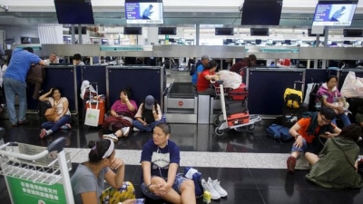 Penumpang terlantar akibat penerbangan mereka di Bandara Hong Kong dibatalkan.