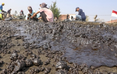 Warga mengumpulkan limbah tumpahan minyak &quot;Oil Spill&quot; yang tercecer milik Pertamina di Pesisir Pantai Cemarajaya, Karawang, Jawa Barat, Rabu (24/7/2019). Pasir yang tercemar minyak tersebut dikumpulkan dan akan dipindahkan ke pabrik penyimpanan limbah B3 (Bahan Berbahaya dan Beracun) untuk dimusnahkan. ANTARA FOTO/M Ibnu Chazar/ama.