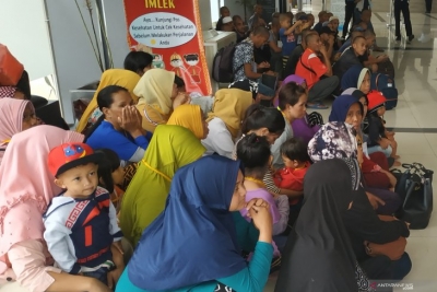 Sejumlah Pekerja Migran Indonesia (PMI) yang dideportasi Pemerintah Malaysia duduk di lantai saat tiba di Pos Lintas Batas Negara (PLBN) Entikong, Kabupaten Sanggau, Kalbar, Rabu (27/2/2019). Jalur pemeriksaan pelintasan orang di perbatasan Indonesia-Malaysia akan tetap buka pada Pemilu 17 April 2019. (ANTARA FOTO/AGUS ALFIAN)