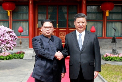 Pemimpin Korea Utara (Korut) Kim Jong-un berjabat tangan dengan Presiden Cina Xi Jinping di Diaoyutai State Guesthouse di Beijing, Cina pada 27 Maret 2018. Xi mengunjungi Korut, Kamis (20/6).