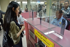 Petugas Imigrasi. Petugas Imigrasi melakukan pemeriksaan paspor Wisman asal Korea saat mendarat di Bandara Internasional Hang Nadim Batam