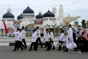 Pelajar melintas di depan Masjid Raya Baiturrahman saat mengikuti pawai keliling kota di Banda Aceh, Aceh, Selasa (30/4/2019).