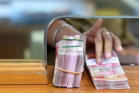 Karyawan memegang mata uang rupiah di gerai penukaran mata uang asing. ilustrasi Foto: Antara/Sigid Kurniawan