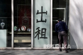 插图: 一名男子看着北京一家商业办公楼的一家封闭商店。